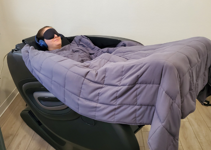 Young woman lying in the zero gravity chair listening to binaural beats